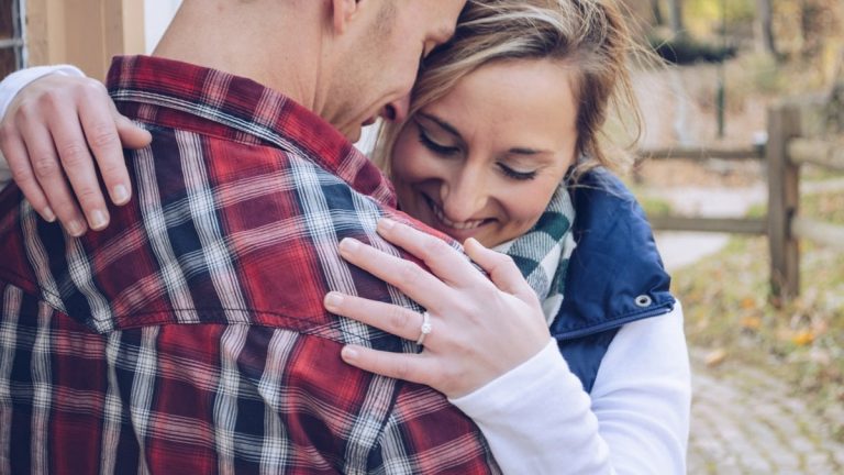 man and woman embracing beside wall