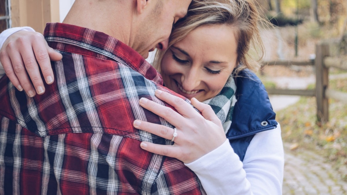 man and woman embracing beside wall